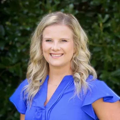 Dr. Ali Kimbrough smiling in a blue top, photographed outdoors