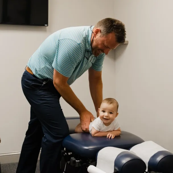 Dr. Jeff Morrey adjusting an infant lying on a treatment table